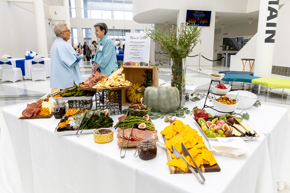 Plated snacks at a reception table, while two people talk to each other behind it.