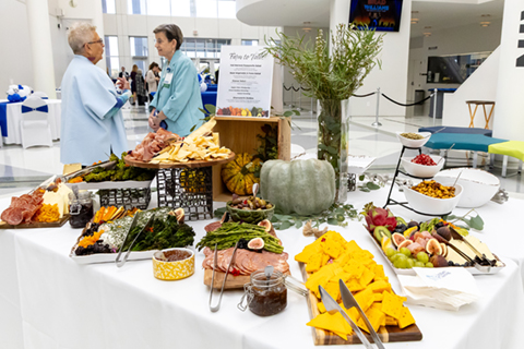 Plated snacks at a reception table, while two people talk to each other behind it.