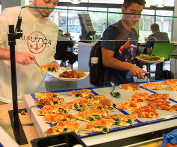 Students grabbing their own pizza from the bar