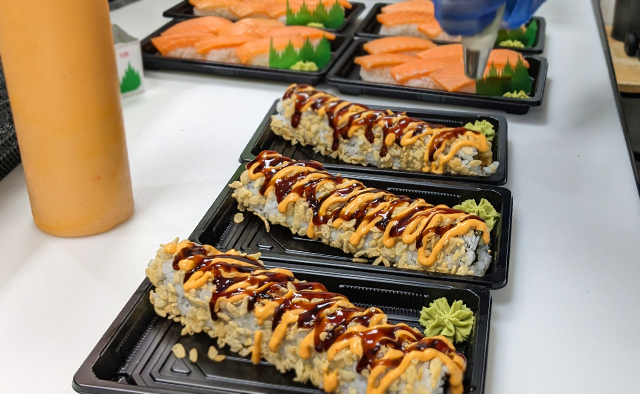 Shrimp Tempura Roll getting dressed by an associate