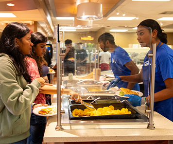 Students talking to an associate at the taco bar