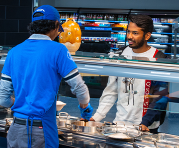Associate serving food to a student at Pan Asia