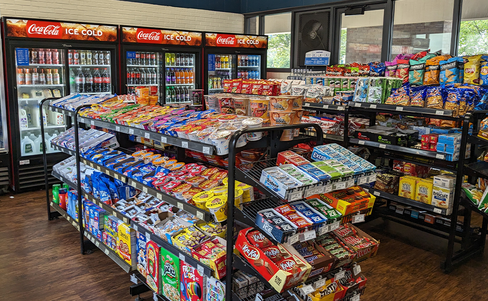 Shelves stocked with snacks, and coolers stocked with beverages in the back