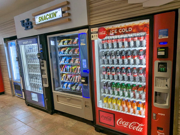 Coca Cola, snack, and Smart Water vending machines in a row in Ellicott Food Court.