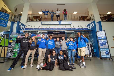 Students wearing apparel from Campus Tees outside of the Tees store in the Student Union. Photo by Onion Studio.