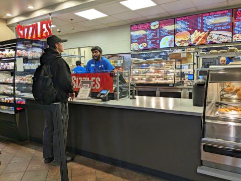 A student ordering at the Sizzles counter.