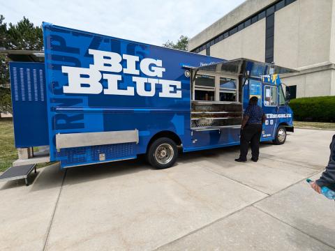 Big Blue food truck parked on South Campus. A customer is ordering food.