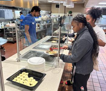 Students putting syrup on their pancakes at Main Street Market