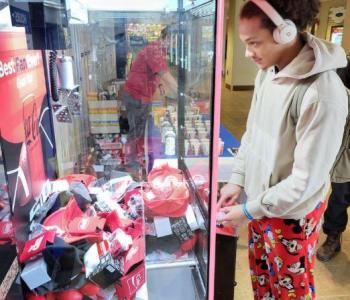 Student using the Coke claw machine