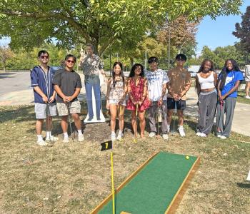 Students posing behind a mini golf set up
