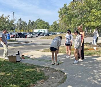 Students playing mini golf