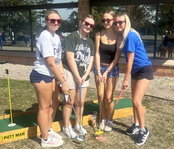 Students posing while playing mini golf