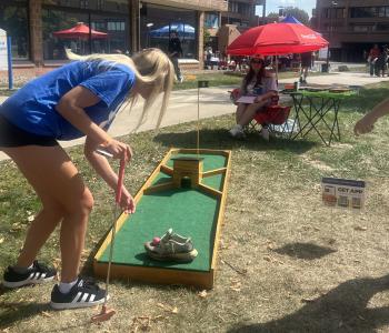Student placing the golf ball preparing to hit it with her golf club