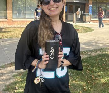 Student posing with her prize of a Coca Cola cup