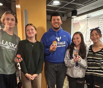 Five students showing their decorated cupcakes