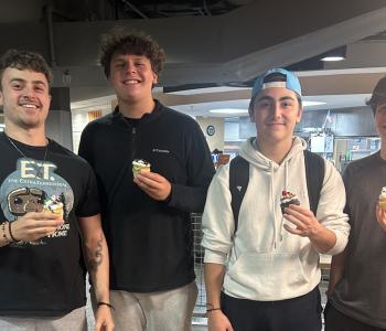 Four students showing their decorated cupcakes