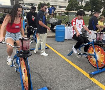 Three students riding blender bikes