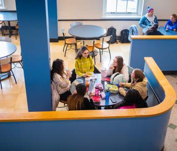 Students sitting and chatting in the seating area outside of Harriman Café. Photo by Douglas Levere.