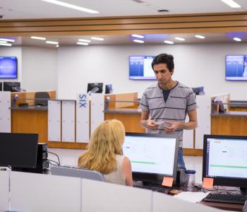 A student talking with an associate at the UB Card section of 1Capen. Photo by Meredith Forrest Kulwicki.