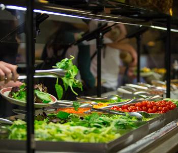 Student preparing their plate with lettuce at the C3 salad bar. Photo by Meredith Forrest Kulwicki.