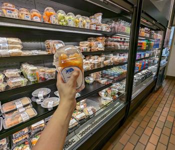 Grabbing a cantaloupe cup at Capen Café in front of the grab & go shelves.