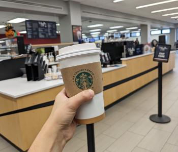 A hot beverage in front of Whispers in Silverman Library.