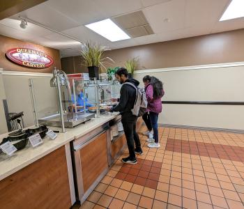 Students getting food from the Queen City Carvery station at Goodyear Dining Center.