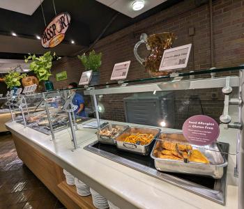 Passport station at Governors Dining Center, which serves international cuisines. A fried food section is next to it with fried haddock fish and fries.