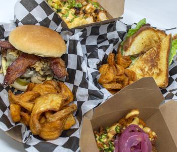 A plethora of food truck offerings: two specialty mac & cheese dishes, and two sandwiches with tornado fries.