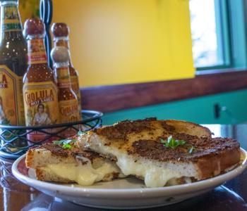 Cotija grilled cheese with the hot sauce center piece and the wall decorations behind it.