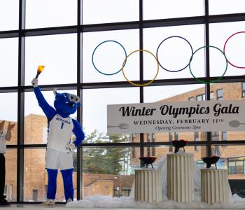 Victor E. Bull holding up the torch next to Marketing Director Ray Kohl, about to light the other torches under the Olympic rings in the opening ceremony inside C3 Lobby. Photo: Meredith Forrest Kulwicki