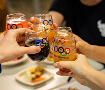 Students clinking their commemorative glasses with a toast at dinner during the event. Photo: Meredith Forrest Kulwicki