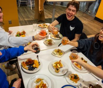 Students clinking their commemorative glasses with a toast at dinner during the event. Photo: Meredith Forrest Kulwicki
