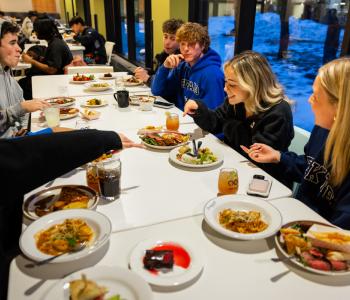 Students sitting and eating international dishes at dinner during the event. Photo: Meredith Forrest Kulwicki